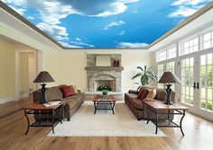 a living room filled with furniture and a sky mural on the ceiling above it's windows