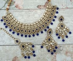 Beautiful flexible Indian Bollywood necklace jewellery set with tikka headpiece & earrings.  Gold base with silver Kundan style stones and dark blue beads.  Earring drop is: 8 cm Bollywood Blue Bridal Necklace Hand Set, Blue Bollywood Jewelry With Stone Work, Blue Kundan Jewelry Sets In Chandbali Style, Blue Bollywood Style Jewelry With Stone Work, Blue Kundan Chandbali Jewelry Sets, Heavy Blue Chandbali Jewelry Sets, Blue Bollywood Jewelry Sets With Stone Work, Blue Kundan Bollywood Jewelry Sets, Blue Kundan Bridal Necklace Hand Set