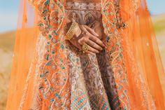 Maria - Raw Silk Indian Bridal Lehenga choli w/ Resham, Pearl & Sequin work Bring your modern-day bridal dreams to life this wedding season in this gorgeous Resham embroidered lengha! Product Specifications: Color Beige, Blue & Orange Fabric Raw Silk & Net Tulle Work Resham, Pearl & Sequin Occasion Bridal, Reception, Engagement Style Indo-western lehenga choli Care Dry Clean Purchase Includes Blouse, Lehenga & Dupatta Blouse: Fabric - Beige silk blouse Work - Pearl, Resham & sequin Neckline - Sc Orange Dupatta With Intricate Embroidery For Reception, Orange Traditional Wear With Intricate Embroidery For Reception, Orange Wedding Sets With Intricate Embroidery, Orange Lehenga With Resham Embroidery For Wedding, Orange Embroidered Sharara For Wedding, Embroidered Orange Sharara For Wedding, Wedding Embroidered Orange Sharara, Orange Choli With Resham Embroidery For Wedding, Orange Wedding Sets With Dupatta