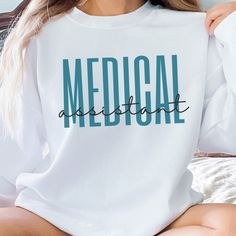 a woman sitting on top of a bed wearing a white shirt with the word medical printed on it