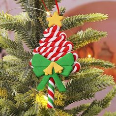 an ornament hanging from a christmas tree decorated with candy canes and stars