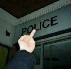 a hand pointing at the police sign above an apple store