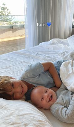 two young children laying on top of a bed