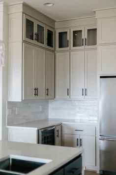 a kitchen with white cabinets and stainless steel appliances