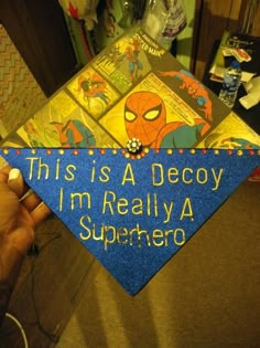 someone is holding up a blue graduation cap that says, this is a decoy i'm really a superhero