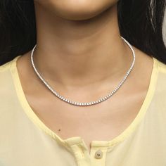 This elegant 4-Prong Tennis Necklace will be sure to add a touch of class to any outfit. Crafted with diamond-like 4-prong stones, this statement piece is sure to shine. With premium quality metal and an understated luminance, this necklace is a timeless piece perfect for both day and night. Classic Silver Single Strand Diamond Necklace, Silver Single Strand Cubic Zirconia Diamond Necklace, Timeless Silver Single Strand Tennis Necklace, Timeless Silver Necklace With Sparkling Stones, Single Strand Cubic Zirconia Tennis Necklace, Classic Rhinestone Necklace With Diamond Accents In Diamond White, Cubic Zirconia Single Strand Tennis Necklace, Minimalist Diamond Cut Tennis Necklace For Formal Occasions, Dazzling Diamond-cut Tennis Necklace