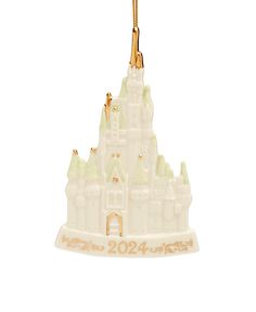 a white ornament with a castle on it's side and a gold chain hanging from the front