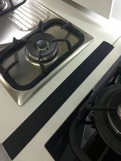 a gas stove top sitting next to a burner and oven with two burners on it