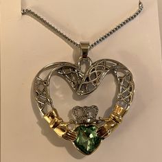 Decorative Claddagh Necklace. Silver And Gold Tone. Green Heart. 18 Inch Chain. Luxury Green Heart-shaped Necklace, Green Heart-shaped Emerald Necklace, Green Heart-shaped Gemstone Necklace, Claddagh Earrings, Claddagh Necklace, Green Heart, Chain Necklaces, Necklace Silver, Chains Necklace