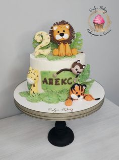 a birthday cake decorated with animals and the number two on it's top tier