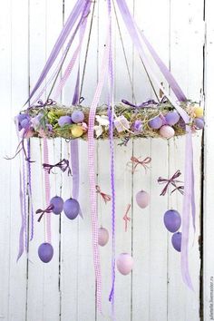 an easter mobile with eggs and ribbons hanging from it