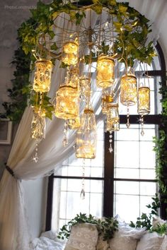 a bed with pillows and lights hanging from it's ceiling in front of a window