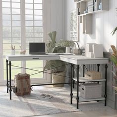 a white desk sitting in front of a window next to a potted green plant