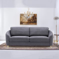 a living room scene with focus on the couch and chandelier hanging above it