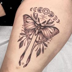 a woman's thigh with a butterfly tattoo on it and an arrow in the middle