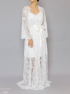 Floor length bridal lace robe with Chantilly French lace Length: 160 cm / 62 in Loose-fitting Bell sleeves Silky ribbon belt Scalloped neckline, lace cuffs and hemline Model is 160 cm/ 5'3'' and wearing a size S Luxury Long Sleeve Feminine Robe, Luxury Long Romantic Robe, Luxury Long Sleeve Lace Dress With Lace Cuffs, Luxury Romantic Lace Dress With Lace Cuffs, Luxury Long-sleeve Lace Dress With Lace Cuffs, Luxury Romantic Dress With Lace Cuffs, Luxury Fitted Lace Dress With Lace Cuffs, Delicate Lace Gown For Ceremonies, Ceremony Gown With Delicate Lace