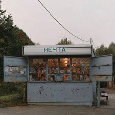 an old metal shop with lots of items on it's sides and the door open