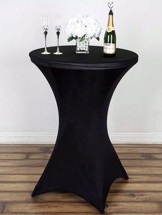 a black table with champagne and flowers on it