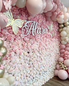 a pink and white floral backdrop with balloons