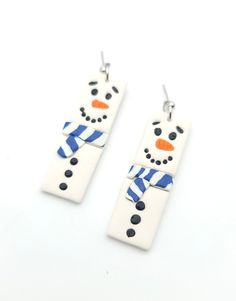 two snowman shaped earrings with blue and white stripes on the bottom, one has an orange nose