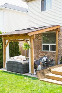 an outdoor living area with patio furniture and pergolated decking on the grass