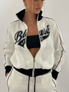 90s style tracksuit jacket and pants with embroidered logo and silver zip. Made with polyester and rib knit. Model is wearing size XS. Sporty Tracksuit With Letter Print For Sports, White Sporty Tracksuit With Letter Print, Sporty Letter Print Tracksuit For Jogging, Sporty White Track Jacket With Letter Print, Stretch Tracksuit For Streetwear And Sports Season, Sporty Stretch Tracksuit For Streetwear, White Tracksuit For Sports In Spring, Stretch Tracksuit For Streetwear During Sports Season, White Long Sleeve Track Jacket For Jogging