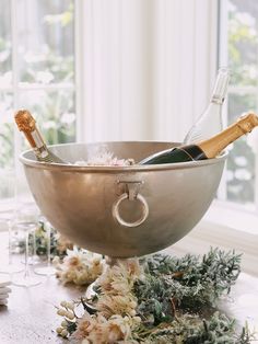 a champagne bottle in a silver bowl on a table