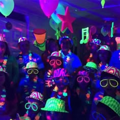 a group of children wearing neon glasses and hats in a room full of party decorations