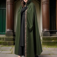 This is a designer image. A majestic, floor-length cloak in a rich, dark green hue, perfect for adding an air of mystery and elegance to any ensemble. The cloak is designed with a generous hood that gracefully frames the face and extends into a full, sweeping cape that offers dramatic flair with every movement. This versatile piece can be seen as ideal for a variety of settings, including fantasy-themed events, renaissance fairs, or as part of a theatrical costume where a regal or mystical chara Fantasy Cosplay Costume For Fall, Gothic Costumes For Fantasy Events In Fall, Fantasy Cosplay Costume For Fall Events, Gothic Cape For Costume Party In Fall, Fall Gothic Cape For Cosplay, Gothic Cosplay Costume For Larp And Halloween, Halloween Fantasy Event Costume Cape, Gothic Medieval Dress For Larp, Gothic Medieval Dress With Historical Design For Halloween