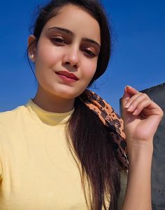 a woman with long hair wearing a yellow shirt