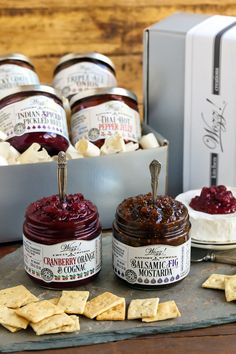 several jars of jam and crackers on a tray