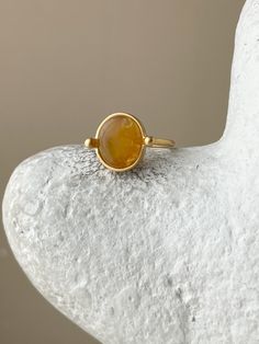 This unique vintage-style ring features a beautiful amber stone. Crafted with attention to detail and quality, this ring is sure to impress with its eye-catching design and classic materials. Its perfect for those seeking a powerful, yet delicate statement piece. The jewelry is presented in a unique piece. 14k Gold Oval Amber Jewelry, Amber Jewelry With Large Stone As Gift, Classic Gold Opal Ring In Sterling Silver, Classic Orange Rings With Polished Finish, Gold Jewelry With Large Round Stone, Vintage Gold Opal Cabochon Ring, Classic Amber Ring In 14k Gold, Vintage Gold Opal Ring With Polished Finish, Classic Gold Opal Gemstone Ring