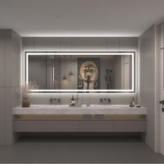 a bathroom with two sinks and a large mirror in the wall above it that is illuminated by lights