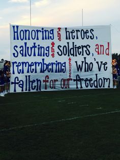 a large sign on the side of a football field that reads honoring, saluting, soldiers, and remembrancers who were fallen for our freedom