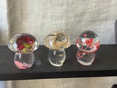 three glass vases with flowers in them on a table