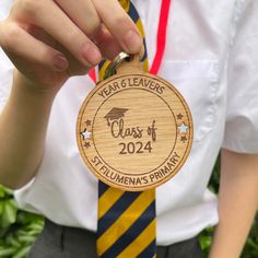 a person wearing a yellow and blue striped tie with a wooden medal that says class of 202