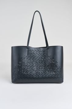 Prepare to be captivated by the chic, contemporary laser cut design of our exclusive Tote bag. Made in Italy in a luxe Napa Leather, it effortlessly blends style and function. The spacious interior ensures you can carry all your essentials with ease, while the interior removable pouch adds functionality - ideal for work, travel, or leisure. Elie Tahari Exclusive Napa Leather Lasercut Tote Handbag 100% Leather Made in Italy Approx. Measurements: Base 16" W x 4.5"D, 11.5 "H, Top Opening 18.5 " W, Perforated Tote Bag For Shopping, Chic Shopping Bags With Perforations, Chic Shopping Bag With Perforations, Luxury Bags With Perforations For Daily Use, Chic Tote Bag With Perforations, Perforated Tote Shoulder Bag For Everyday Use, Everyday Perforated Tote Shoulder Bag, Leather Bags With Perforations For Everyday Use, Leather Bag With Perforations For Daily Use