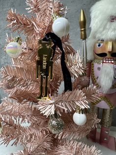 a pink christmas tree decorated with nutcrackers and ornaments