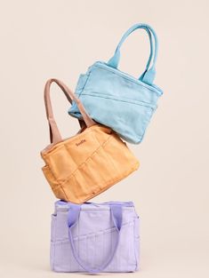 three purses stacked on top of each other, one in blue and the other in yellow