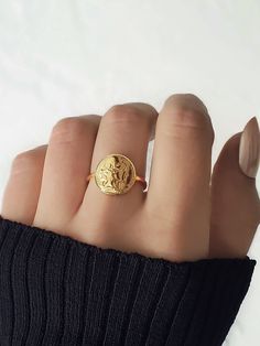 MARIANNE RING: ✦ Marianne face engraved ring inspired by old french gold coin COMPOSITION: ✦ Gold plated 18K Stainless Steel SIZE: ✦ Coin: 13mm ✦ Ajustable ring from U.S size: 5.75 to U.S size 9 JEWELLRY CARE: ✦ This jewel is made of stainless steel which makes it tarnish resistant and waterproof. Over time, the golden layer can acquire a slight patina.  In order to keep your jewel as the first day, it is recommended to remove it regularly for the shower, sea, swimming pool, sports and to avoid contact with cosmetics.  Your jewel can be cleaned with a dry microfiber cloth. Keep it in a dry place and in its pouch so that it keeps all its shine! Gold Coin Ring, Sea Swimming, French Coins, Ring Inspired, Ancient Coin, Engraved Ring, Coin Ring, Gold Coin, Old Coins