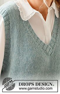 a woman wearing a blue sweater vest and white shirt with her hair in a bun