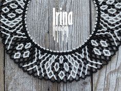 a black and white beaded necklace hanging on a wooden wall with the word irna written