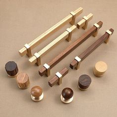 several wooden pegs and knobs are arranged on a beige surface, including one with wood handles