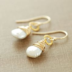 I've made these keishi pearl dangle earrings with beautiful white keishi pearls suspended from twisted 24k gold vermeil rings. These are clean and classic, and the pearls have a lovely organic touch that makes them unique. Total length is approximately 1 1/8 inches (2.9 cm), and the pearls are about 11 mm x 8 mm. All wire and the earwires are 14k gold filled. Pearls are June's birthstone, so these make a great gift for someone with a birthday or anniversary in that month. See more- Pearl jewelry Yellow Gold Wire Wrapped Pearl Earrings Gift, Wire Wrapped Yellow Gold Pearl Earrings Gift, Gold Briolette Pearl Earrings For Anniversary, Anniversary Wire Wrapped Pearl Earrings, Gold Schmuck, Pearl Jewels, Pearl Dangle Earrings, June Birthstone Jewelry, June Birthstone