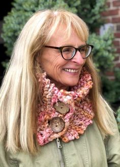 an older woman wearing glasses and a knitted cowgirl neck scarf with buttons on it