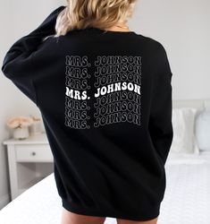 Honeymoon Sweatshirt, Custom Last Name, Custom Mrs Hoodie, Custom Bride Sweater, Custom Mrs Sweater, Wedding Hoodie, Wedding Sweater, Custom Name Sweater, Custom Name Hoodie, Wedding Gift, Honeymoon Hoodie, Last Name Hoodie, Mrs Hoodie, Mrs Sweatshirt,  Brand: Rabbit skin-Toddlers Brand: Gildan- youth hoodies and sweatshirts Brand: Gildan and Tultex -Adult hoodies and sweatshirts If you have a specific brand you prefer, please let us know, otherwise, we will use the inventory we have, which incl Crew Neck Sweatshirt With Name Print For Fall, Fall Crew Neck Hoodie With Name Print, Black College Sweatshirt With Name Print, Mr And Mrs Sweatsuit, Fall Crew Neck Sweatshirt With Name Print, Winter Long Sleeve Sweatshirt With Name Print, Winter Crew Neck Sweatshirt With Name Print, Fall Sweatshirt With Name Print And Long Sleeves, Relaxed Fit White Sweatshirt With Name Print