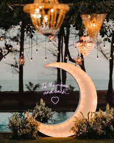 the moon and stars are lit up in front of some chandeliers with lights hanging from them