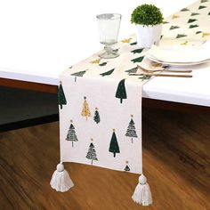 a table topped with a white table cloth covered in christmas trees