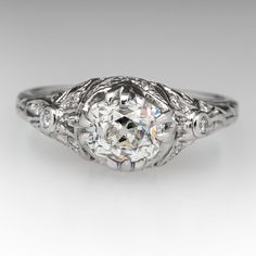 The ring is centered with one (1) old mine cut diamond four-split prong head. The ring features a pierced design and is accented with sixteen (16), bead/bezel set, round brilliant cut diamonds. Engraved wheat motifs accent the shank. The ring measures 8.0mm at the top, rises 8.0mm above the finger, tapering to 1.8mm wide and 1.0mm thick at the base of the shank. Timeless Classic Cut Diamond Ring With Single Cut Diamonds, Timeless Diamond Ring With Single Cut Diamonds, Timeless Diamond Ring With Single Cut, Timeless Rings With Classic Cut Single Diamonds, Heirloom Diamond White Jewelry In Classic Cut, Classic Rose Cut Diamond Wedding Jewelry With White Topaz, Heirloom Asscher Cut Diamond Ring With Rose Cut Diamonds, Heirloom Asscher Cut Rose Diamond Ring, Heirloom Ring With Center Stone In Classic Cut