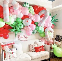 a living room filled with lots of balloons and decorations on the wall behind a white couch